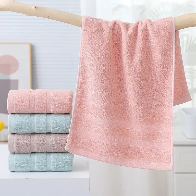 Stack of pink and light blue towels on a wooden rack with a blurred background
