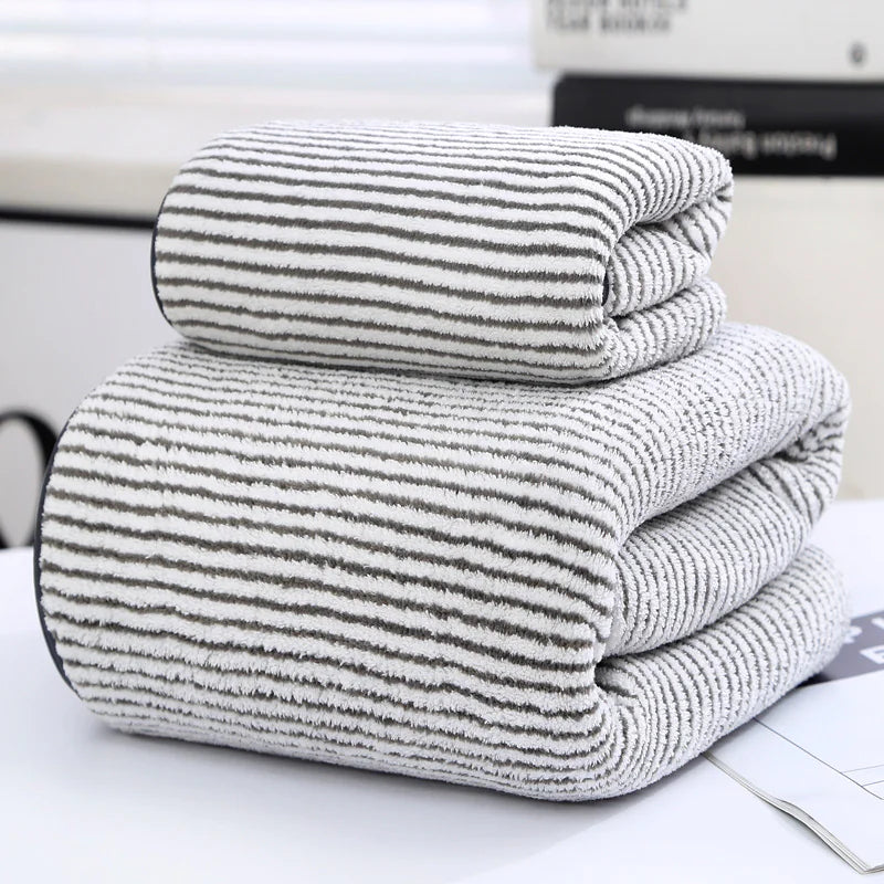 Stack of folded striped towels on a white surface