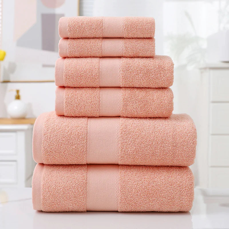Stack of pink towels on a white surface with a blurred background