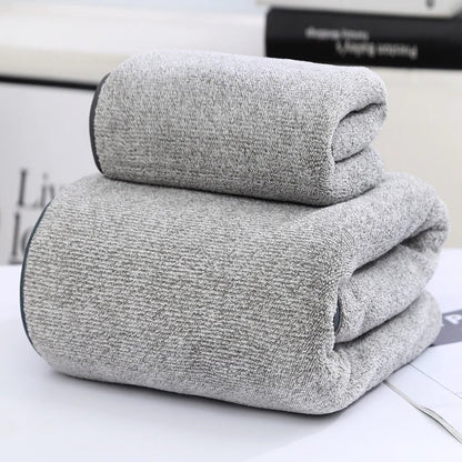 Two folded gray towels on a white surface with a blurred background