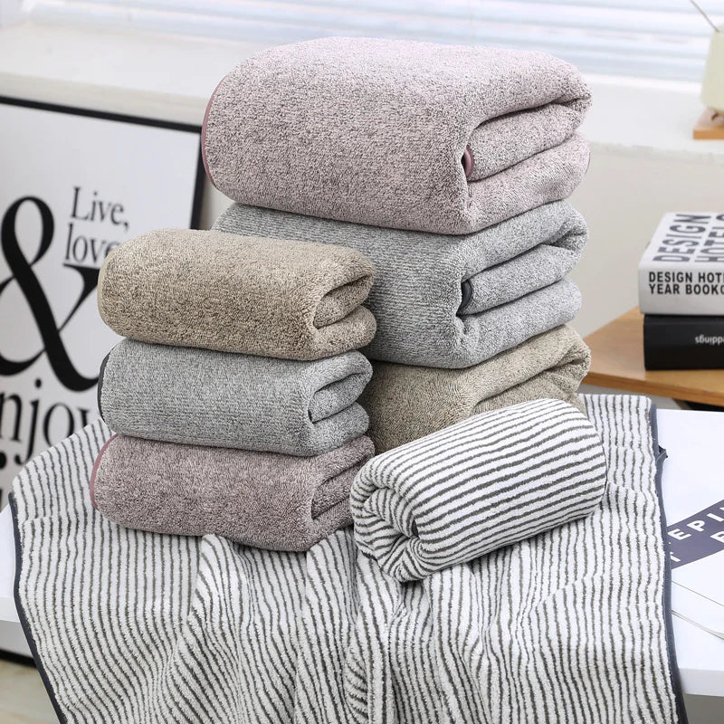 Stack of folded towels on a surface with a decorative background