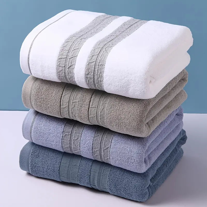 Stack of folded towels in white, gray, blue, and green on a light blue background