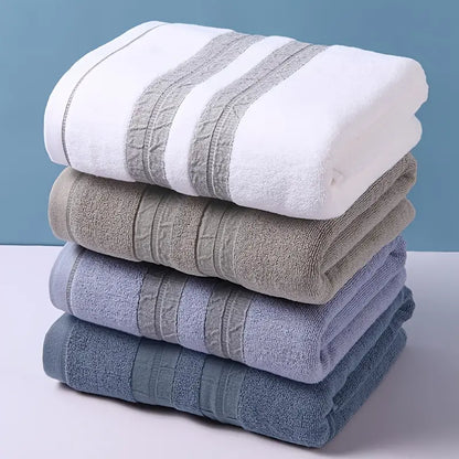 Stack of folded towels in white, gray, blue, and green on a light blue background